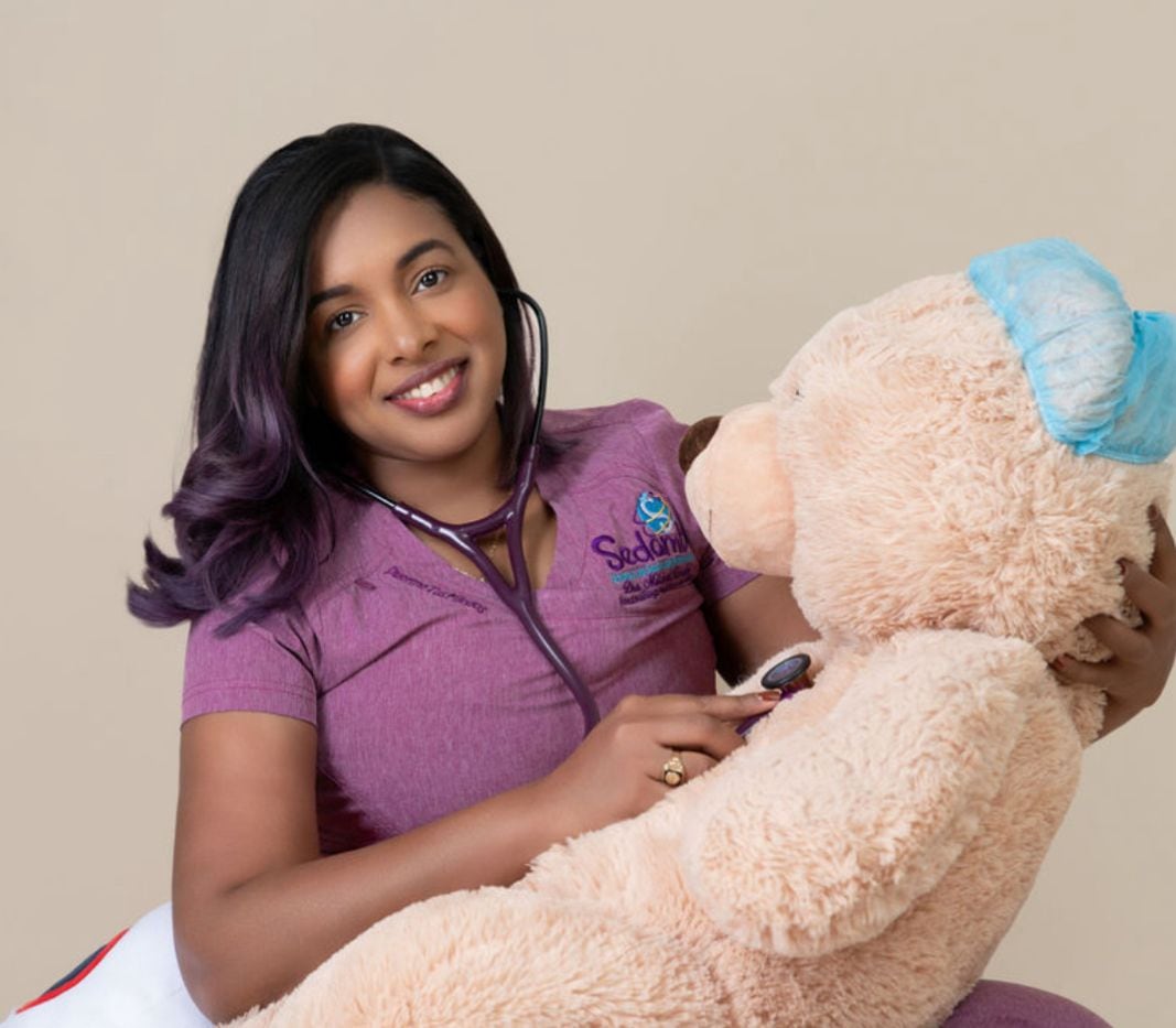 Dra. Mildred acompañando a paciente pediátrico con peluche